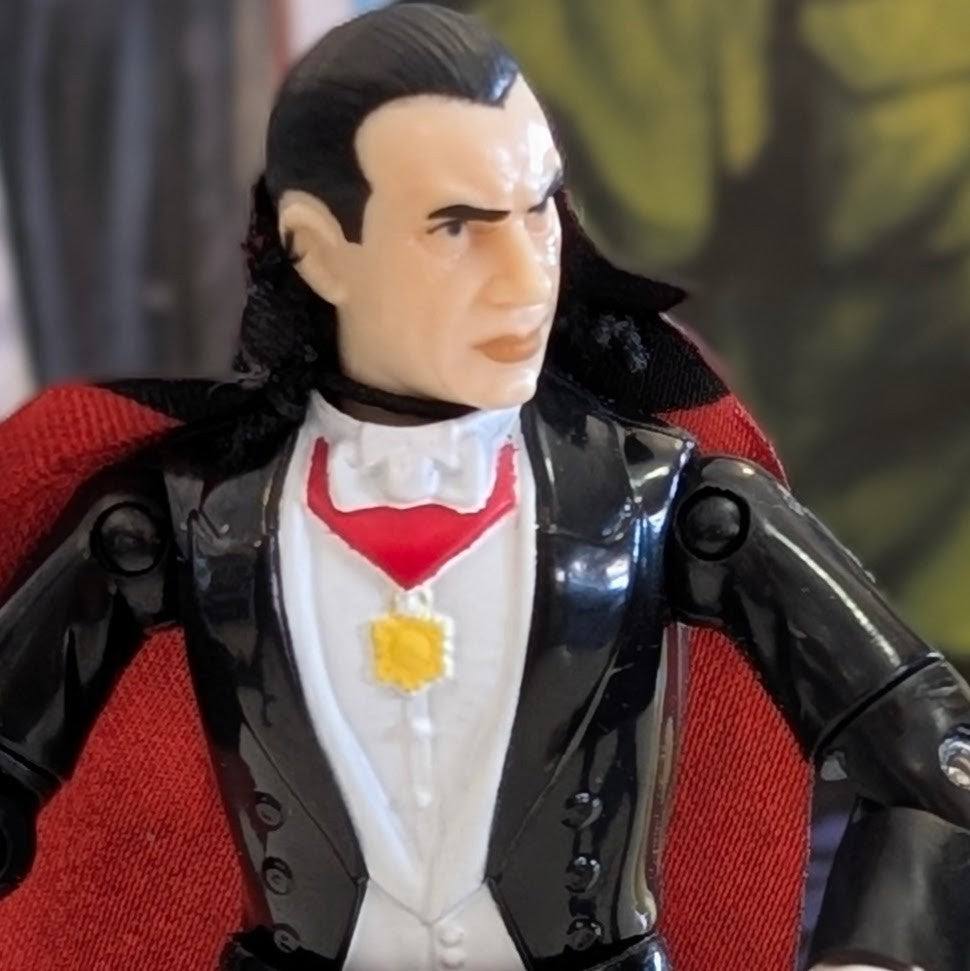 Universal Monsters Dracula 3 3/4-inch ReAction figure by Hasbro wearing black suit and red cape close-up on display