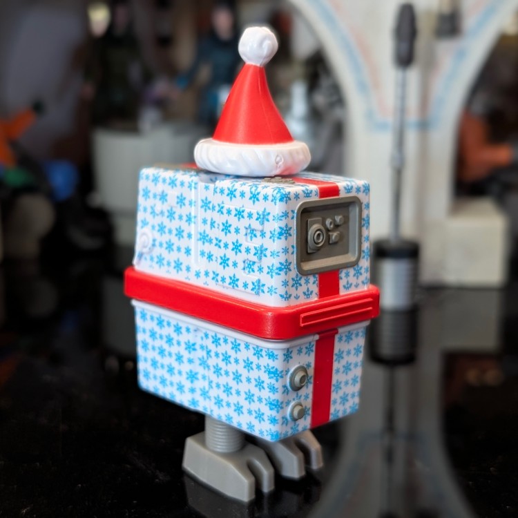 Hasbro Gronk Blue Christmas Present Droid action figure decorated with snowflakes and red Santa hat holiday design