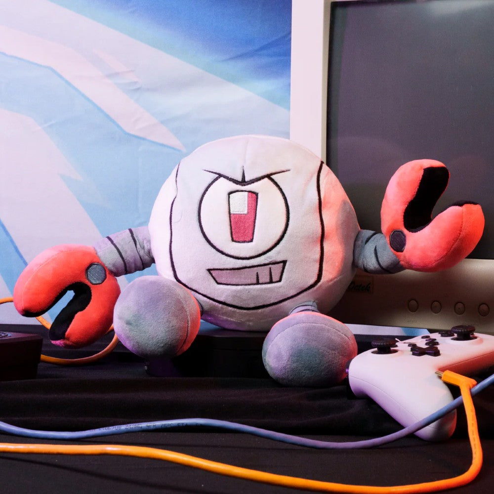 Kaboodle Plush Gameoverse Official Collectible Figure by Glitch Productions posed with retro gaming controllers and monitor.