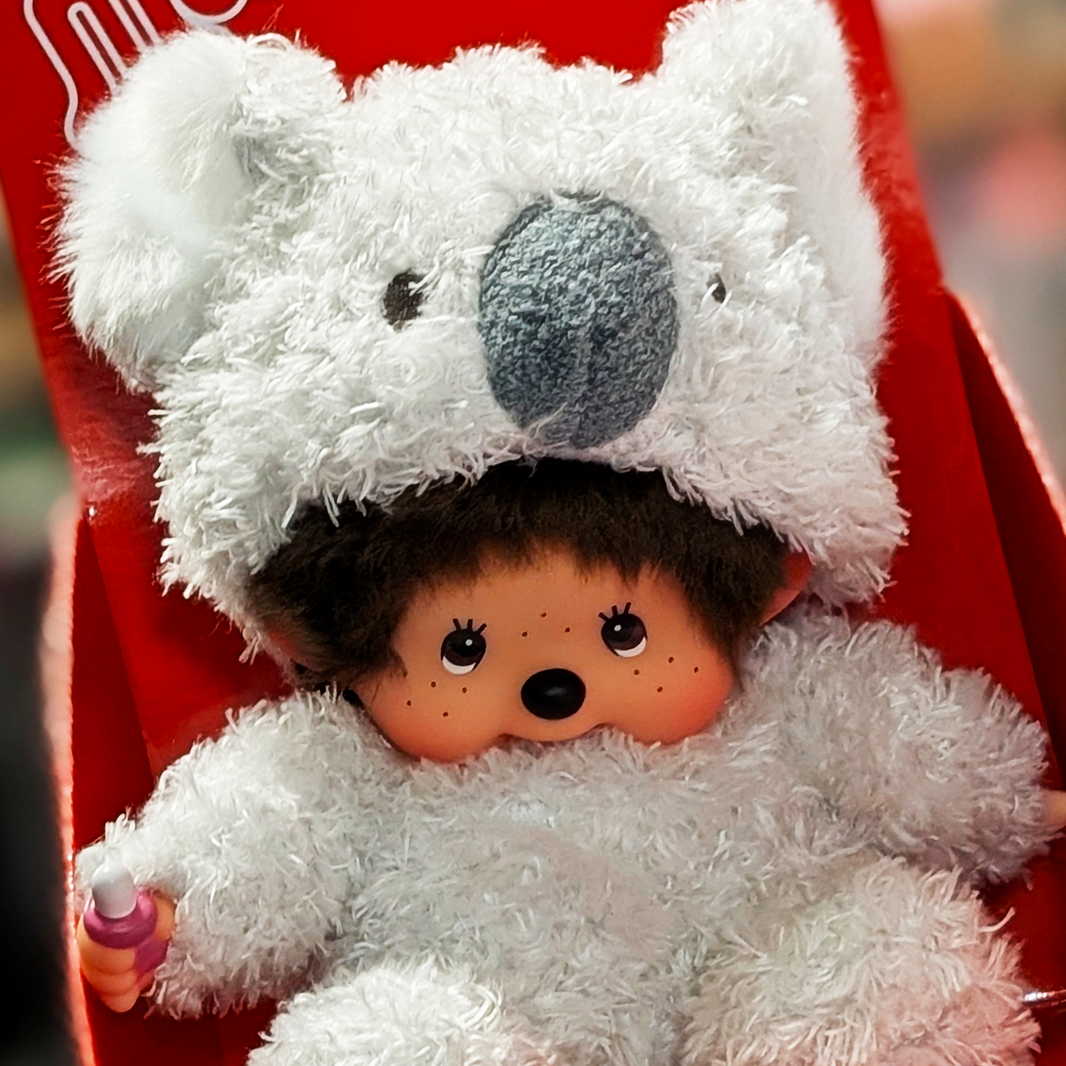 Sekiguchi Monchhichi sitting plush doll dressed in fluffy white koala costume with thumb in mouth