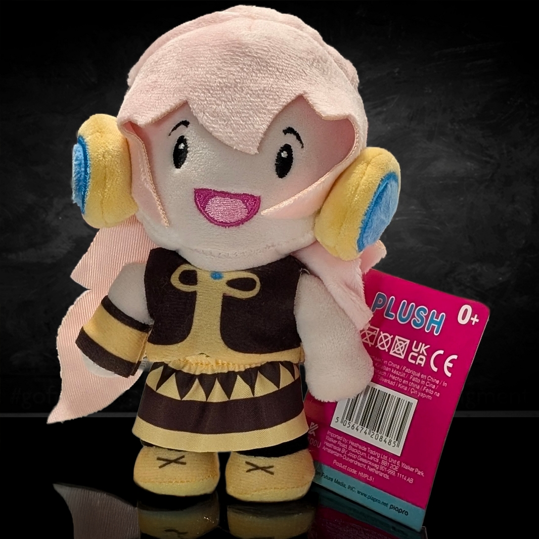 UCC 6-inch Megurine Luka plush with pink hair, yellow and blue headphones, wearing brown outfit and holding product tag
