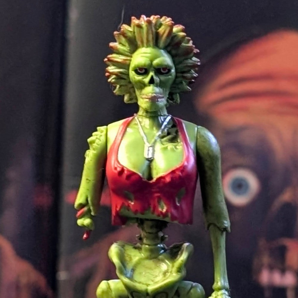 Super7 “Trash” Neon Green Female Zombie figure with torn red top and spiked hair against dark horror backdrop