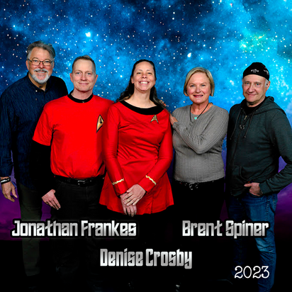 Group of five smiling adults posing in front of a starry space background with names and 2023 text below