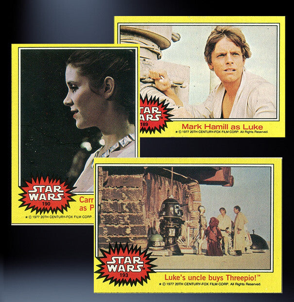 Three vintage Topps Star Wars 1977 trading cards featuring Princess Leia, Luke Skywalker, and a scene with Threepio