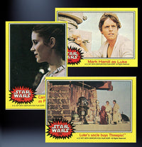 Three vintage Topps Star Wars 1977 trading cards featuring Princess Leia, Luke Skywalker, and a scene with Threepio