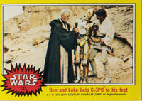 1977 Topps Star Wars trading card showing Ben Kenobi and Luke Skywalker helping C-3PO stand in desert scene