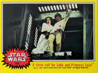 Topps 1977 Star Wars trading card featuring Luke Skywalker and Princess Leia in action scene from film