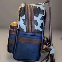 Side angle of Loungefly Toy Story mini backpack featuring cow print and brown leather straps detail