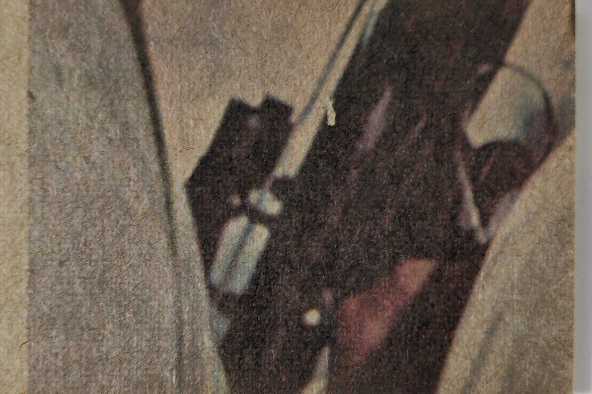 Close-up of vintage 1977 Topps Star Wars trading card showing character holding a weapon in muted colors