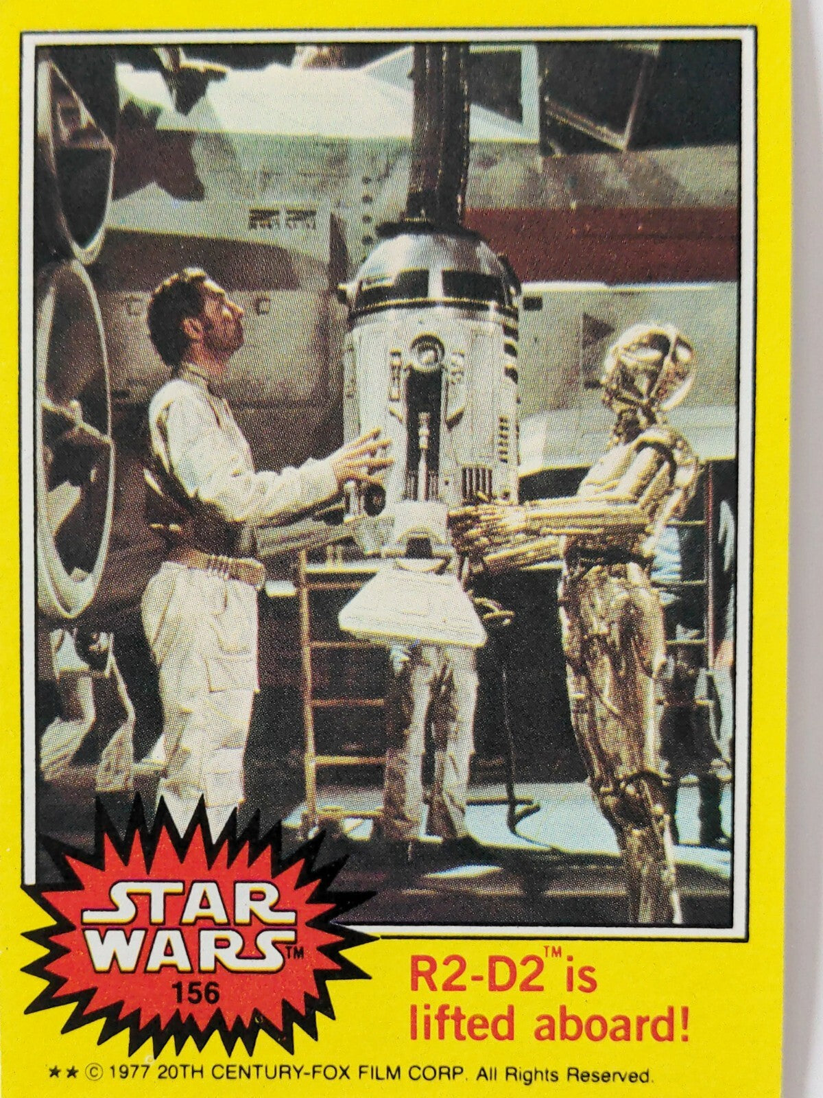 1977 Topps Star Wars trading card featuring R2-D2 being lifted aboard with C-3PO and technician in background