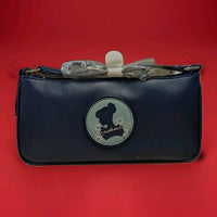 Danielle navy crossbody bag with Cinderella silhouette patch and floral details on front against red background