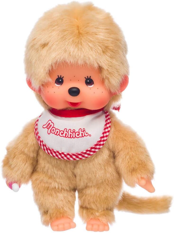 Sekiguchi Monchhichi beige plush doll with soft fur, red and white bib, cute face, and thumb-sucking pose.