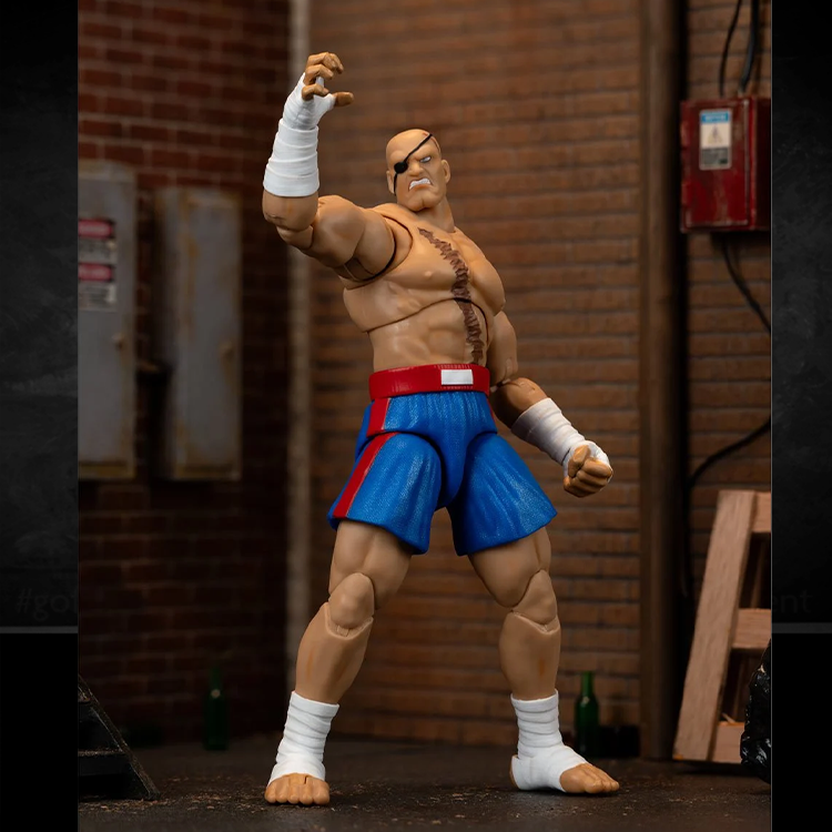 Jada Toys Ultra Street Fighter II Sagat deluxe 6-inch action figure in blue shorts posed in brick background setting