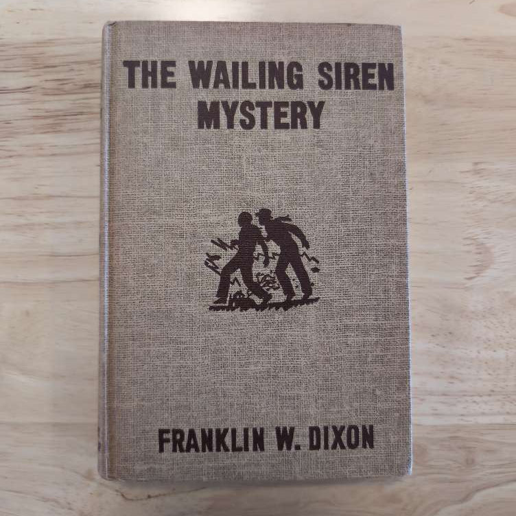 Vintage hardcover of The Wailing Siren Mystery by Franklin W. Dixon from Grosset & Dunlap, Inc. with brown cover