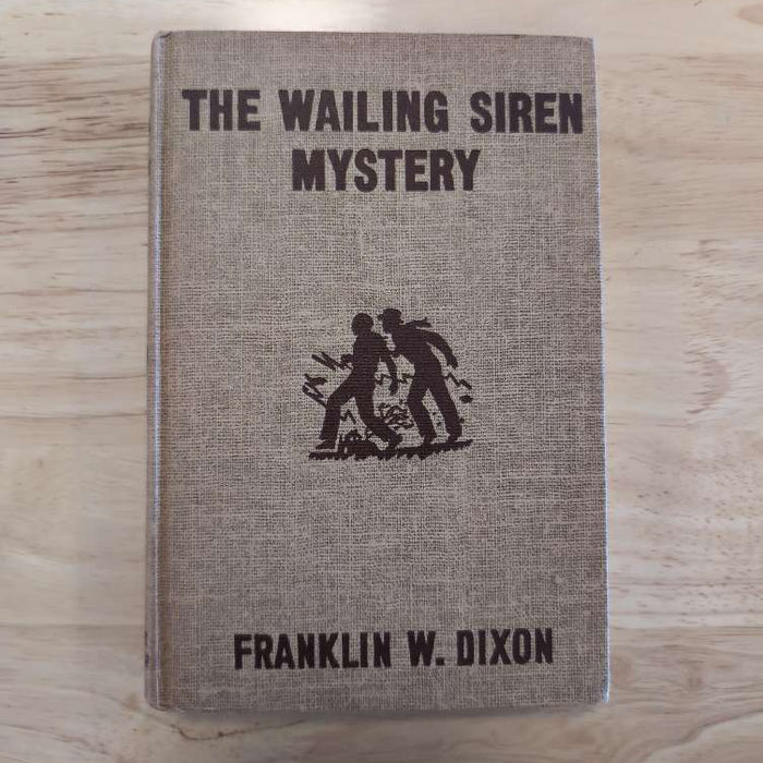 Vintage hardcover of The Wailing Siren Mystery by Franklin W. Dixon from Grosset & Dunlap, Inc. with brown cover