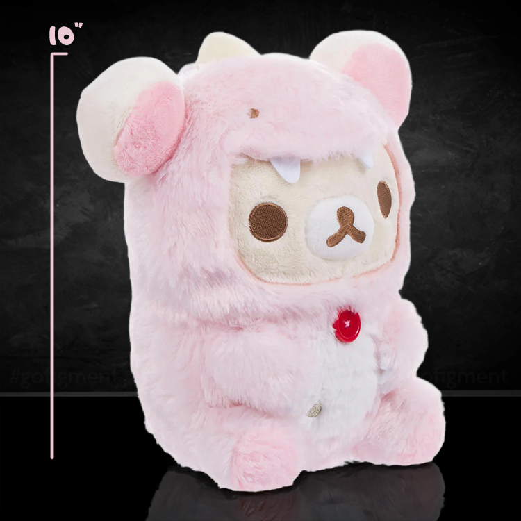 Korilakkuma plush in pink dinosaur costume with white belly and red button sitting on black background San-X original