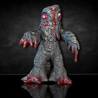 Super7 Godzilla Hedorah vinyl figure with textured body and red details in dynamic pose on reflective black surface