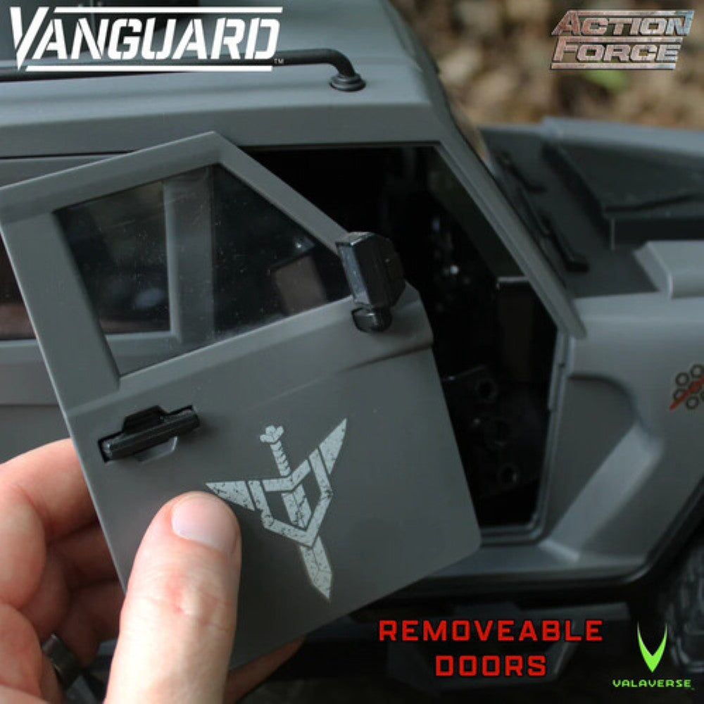 Close-up of a dark gray toy vehicle with a removable door, Vanguard and Action Force logos, and a hand holding the door