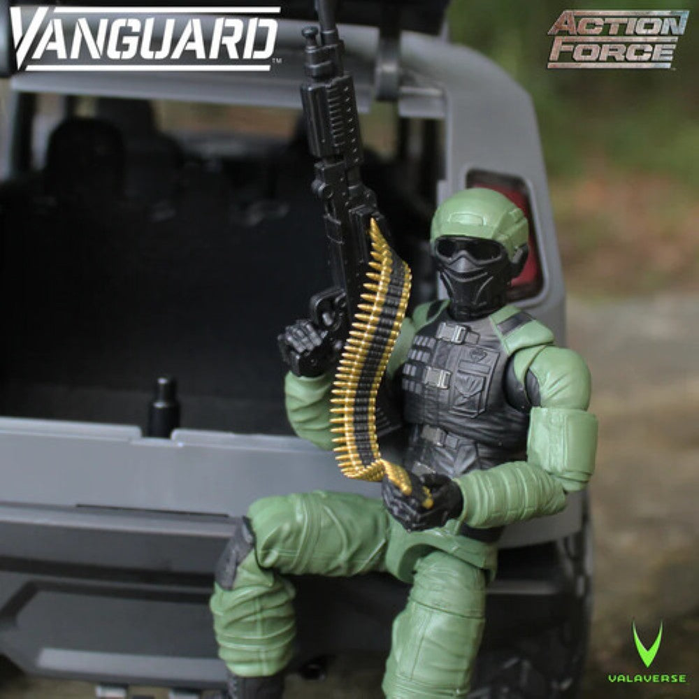 Green masked action figure seated in a military vehicle, holding a machine gun with an ammunition belt