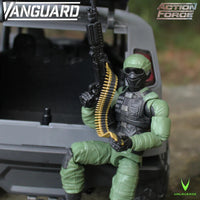 Green masked action figure seated in a military vehicle, holding a machine gun with an ammunition belt