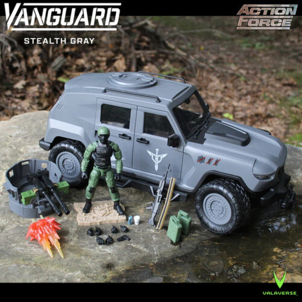 Gray military-style toy vehicle with green action figure, weapons, and accessories displayed outdoors