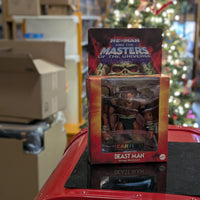 Beast-Man Masters of the Universe Origins Deluxe action figure in Mattel packaging on red surface with blurred background