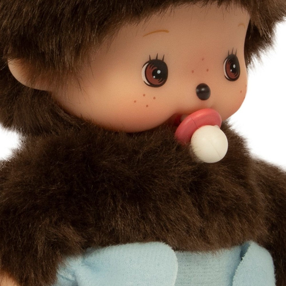 Close-up of a plush toy with brown fur and a light blue garment on a white background