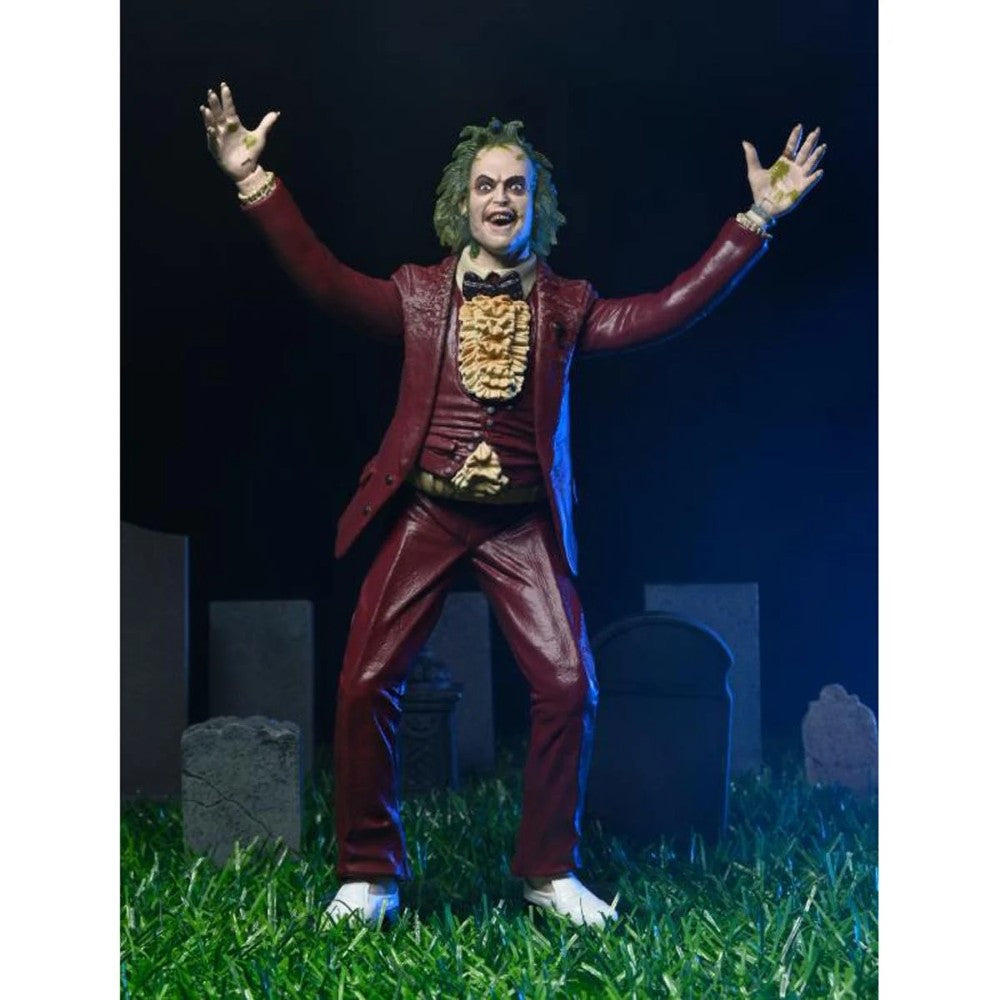 Beetlejuice (1988) Red Tuxedo NECA 7-Inch Scale Action Figure posed with arms raised on grass with tombstones by Neca