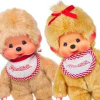 Two plush Monchhichi dolls with red-and-white embroidered bibs, one featuring a red bow on its head, both smiling.