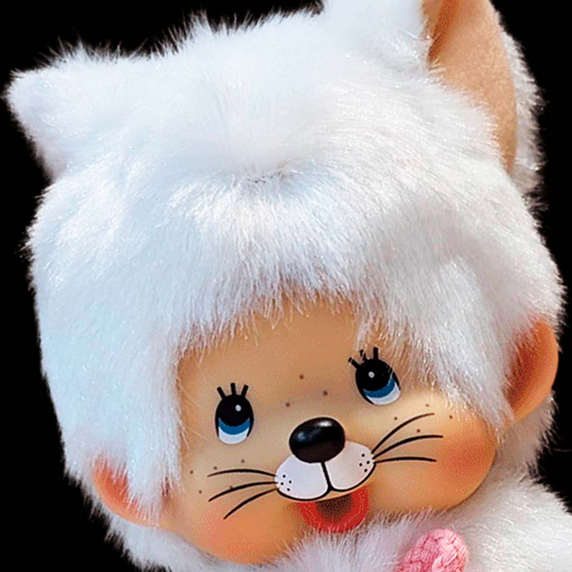 Close-up of Sekiguchi Monchhichi plush doll dressed as a white cat with blue eyes and pink nose