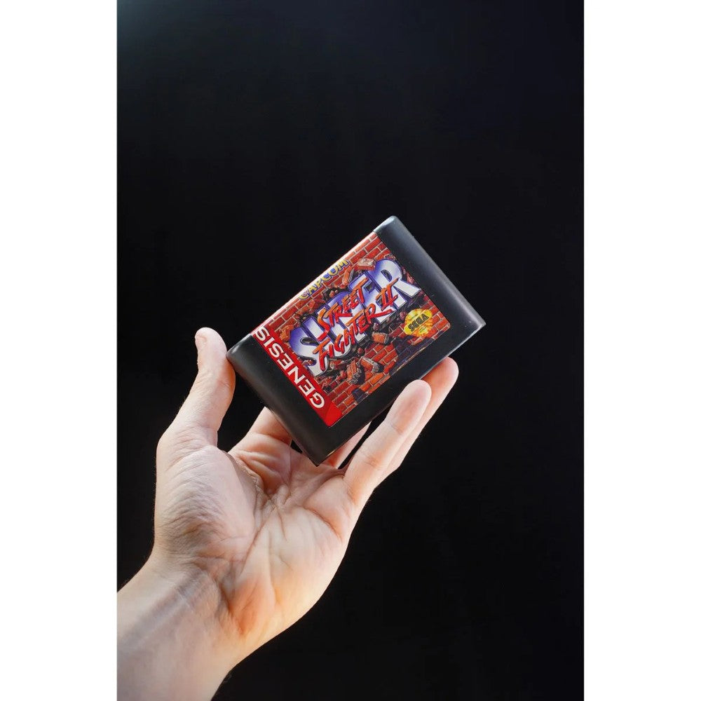 Console Heroes Sega Genesis Genesis Street Fighter II Cartridge Diorama Playset held in hand floating on black background.