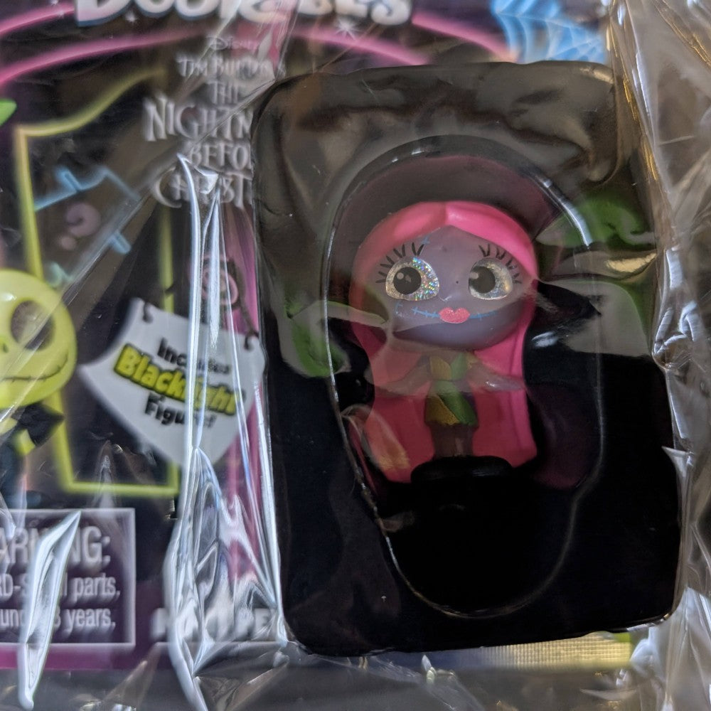 Go Figment Disney Doorables mini-figure with pink hair and big eyes from Tim Burton's The Nightmare Before Christmas series in blind box packaging