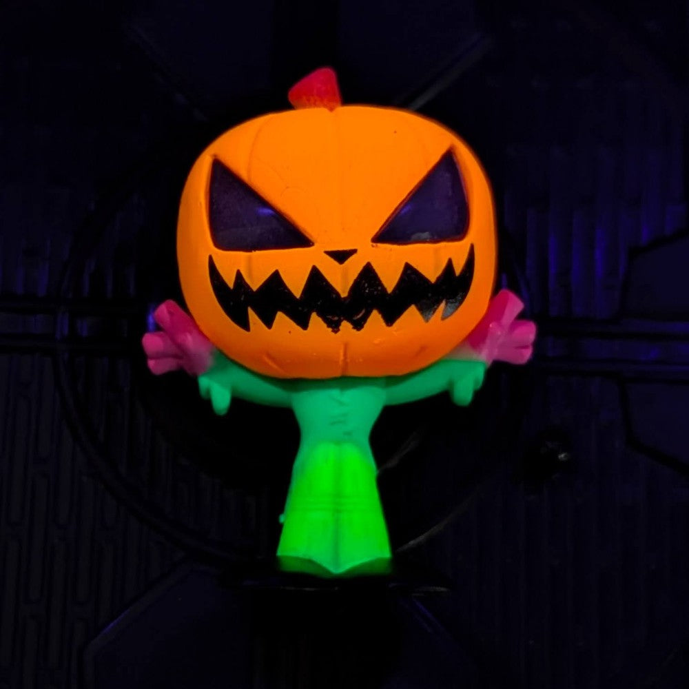 Go Figment black light figure of a glowing green character with an orange pumpkin head from Disney Doorables U-Pick series