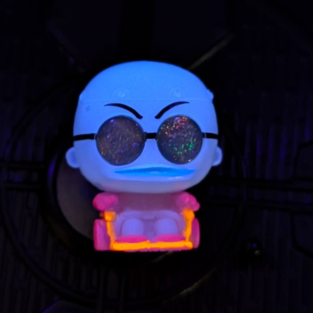 Go Figment Disney Doorables black light mini-figure with glitter lenses and glowing pink and orange neon chair under dark lighting