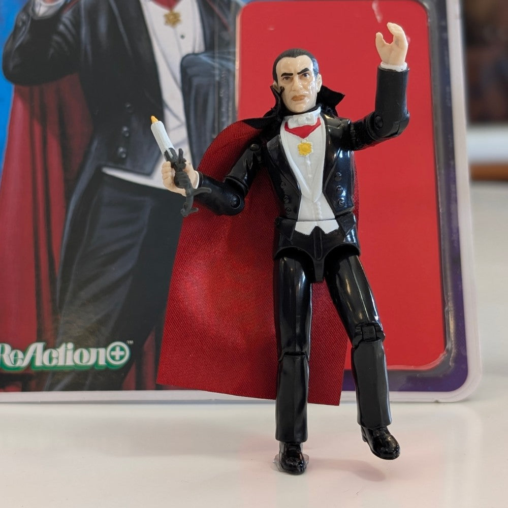 Universal Monsters Dracula 3 3/4-inch ReAction+ figure by Hasbro with red cape and candle accessory on display surface