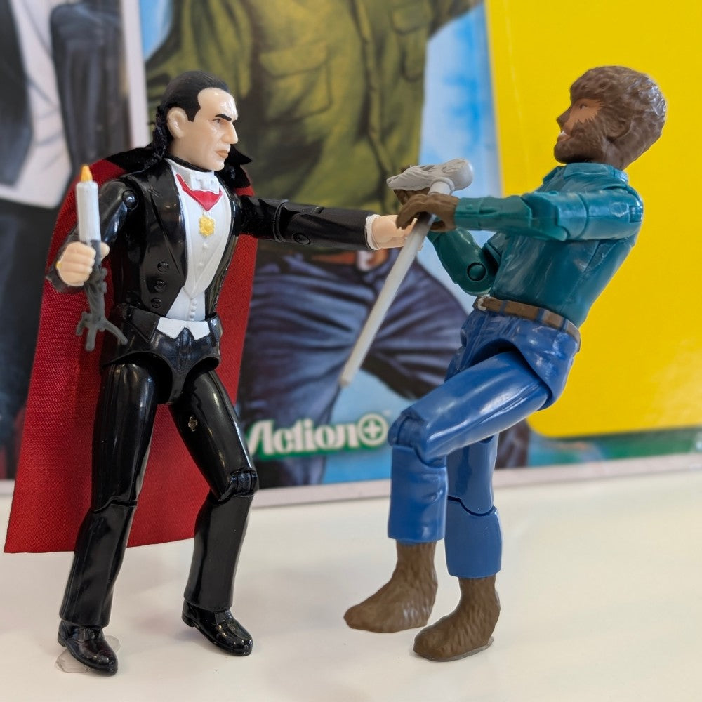 Universal Monsters Wolf Man 3 3/4 Reaction+ figure by Hasbro with Dracula figure holding candle on display surface