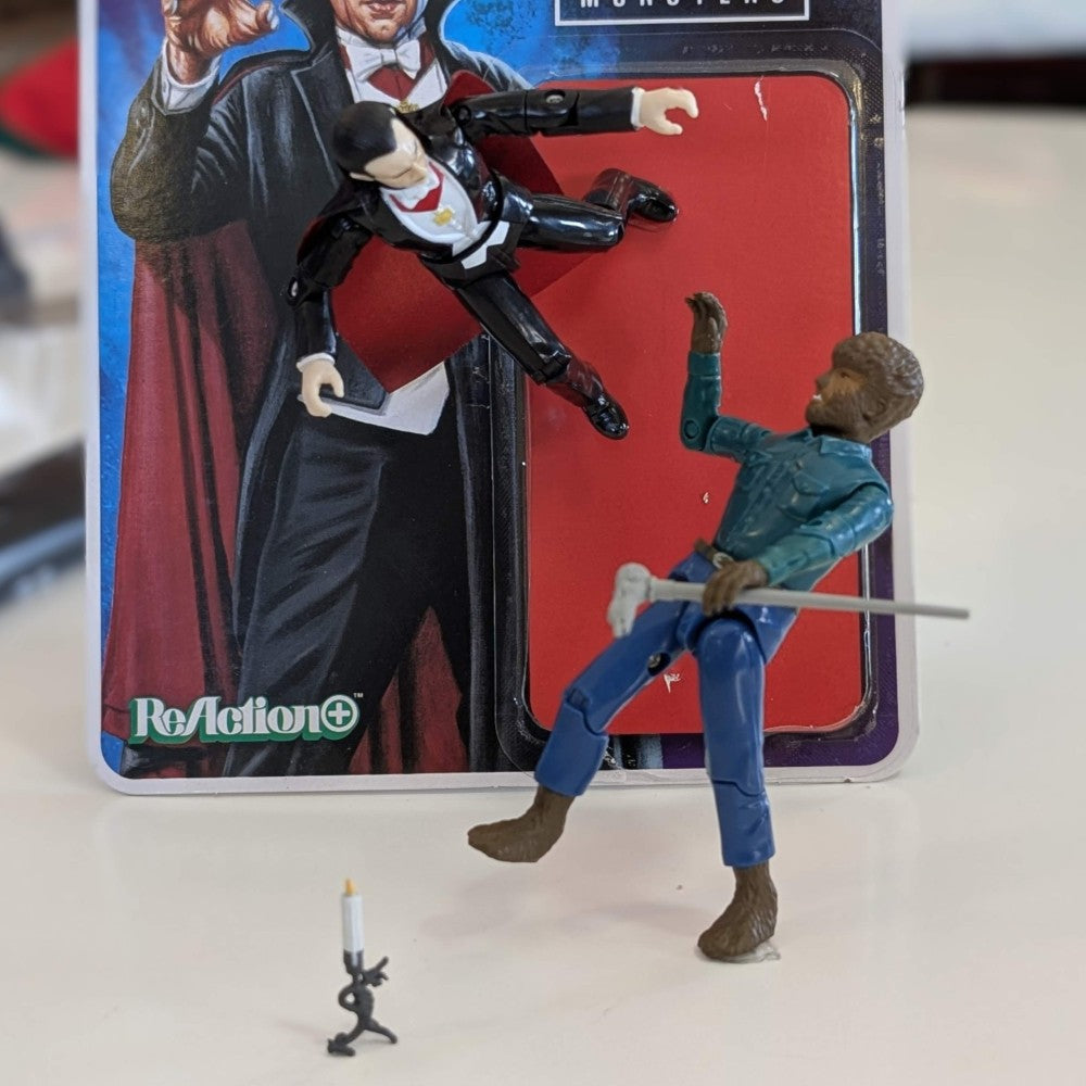 Universal Monsters Dracula 3 3/4-inch ReAction+ figure by Hasbro with Wolfman figure and candlestick on table
