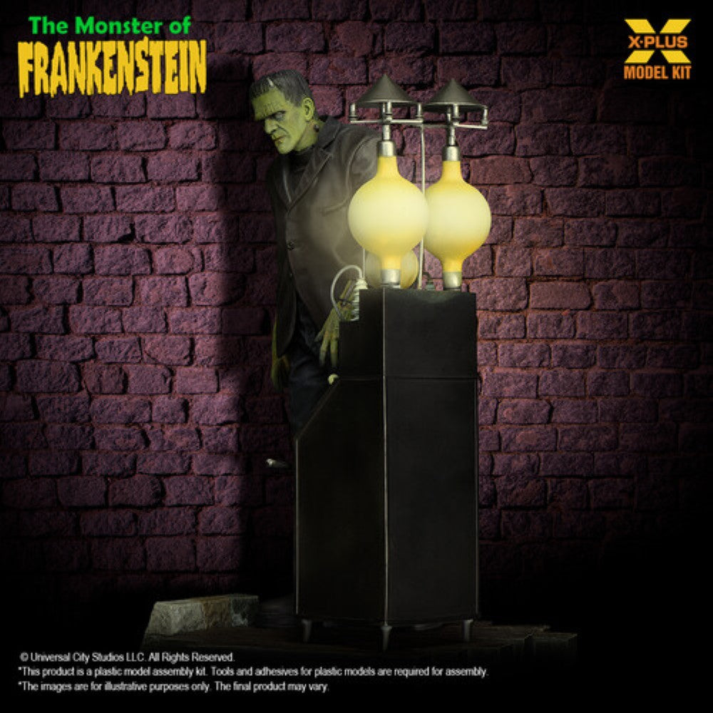 Model kit of Frankenstein's monster beside a vintage-style laboratory apparatus against a brick wall background