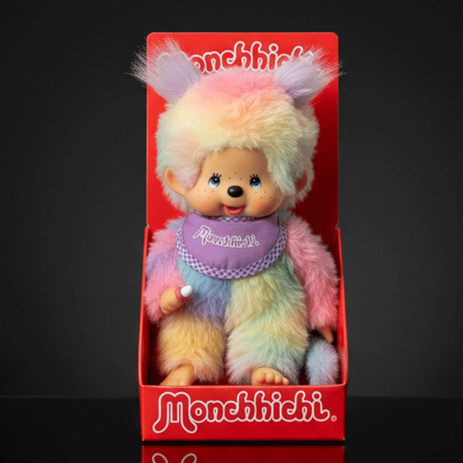 Sekiguchi 8-inch Monchhichi girl doll in pastel tie-dye plush seated in red branded display box