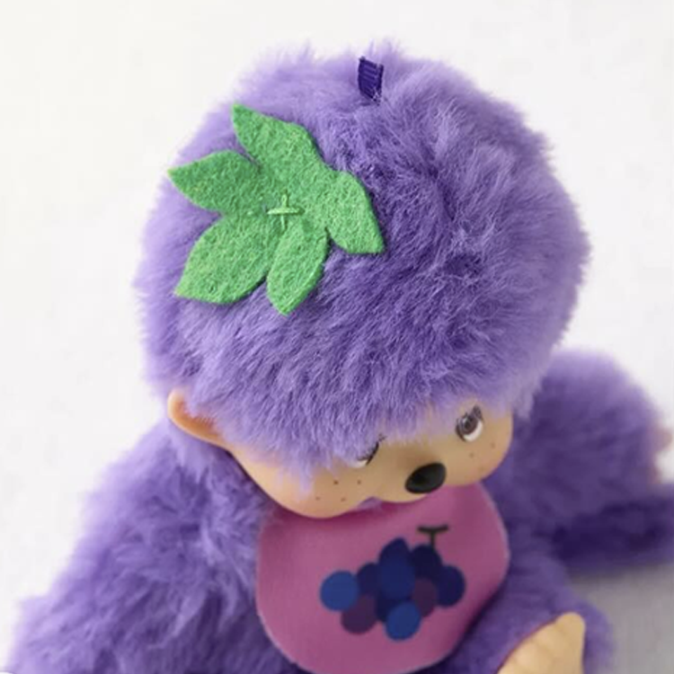 Sekiguchi Monchhichi plush in grape purple with soft fur and green leaf detail on head, 5.5 inches tall collectible toy.