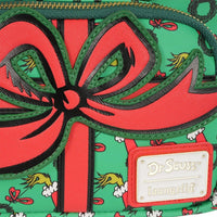 Close-up of Loungefly How the Grinch Stole Christmas mini-backpack with red bow and Dr. Seuss logo badge