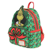 Loungefly mini-backpack with Grinch peeking through wreath pattern and large red bow detail on front pocket