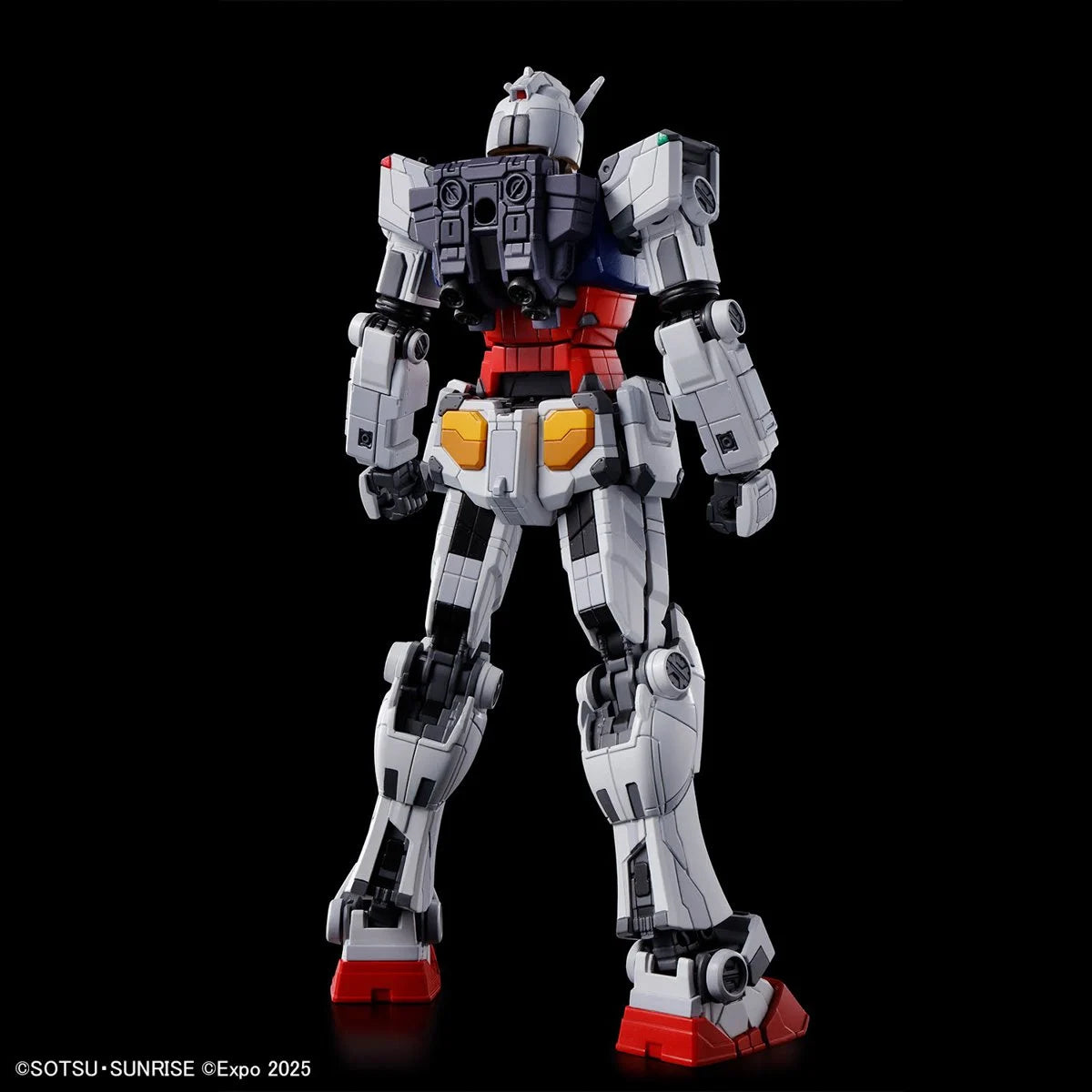 Detailed rear view of a white and red Gundam figure with mechanical paneling against a black background