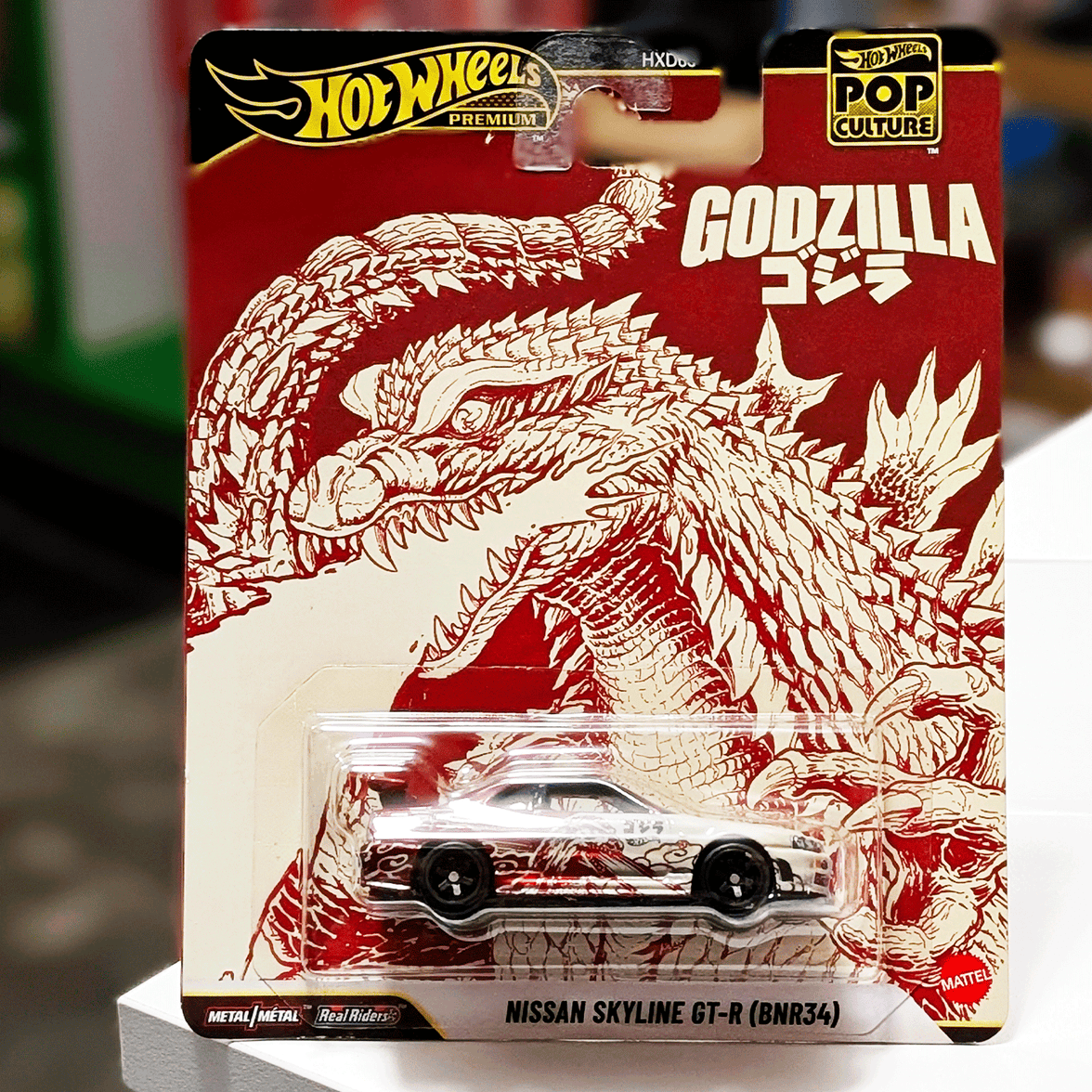 Mattel Hot Wheels Premium Nissan Skyline GT-R BNR34 Godzilla Pop Culture 2026 die-cast car front view in package