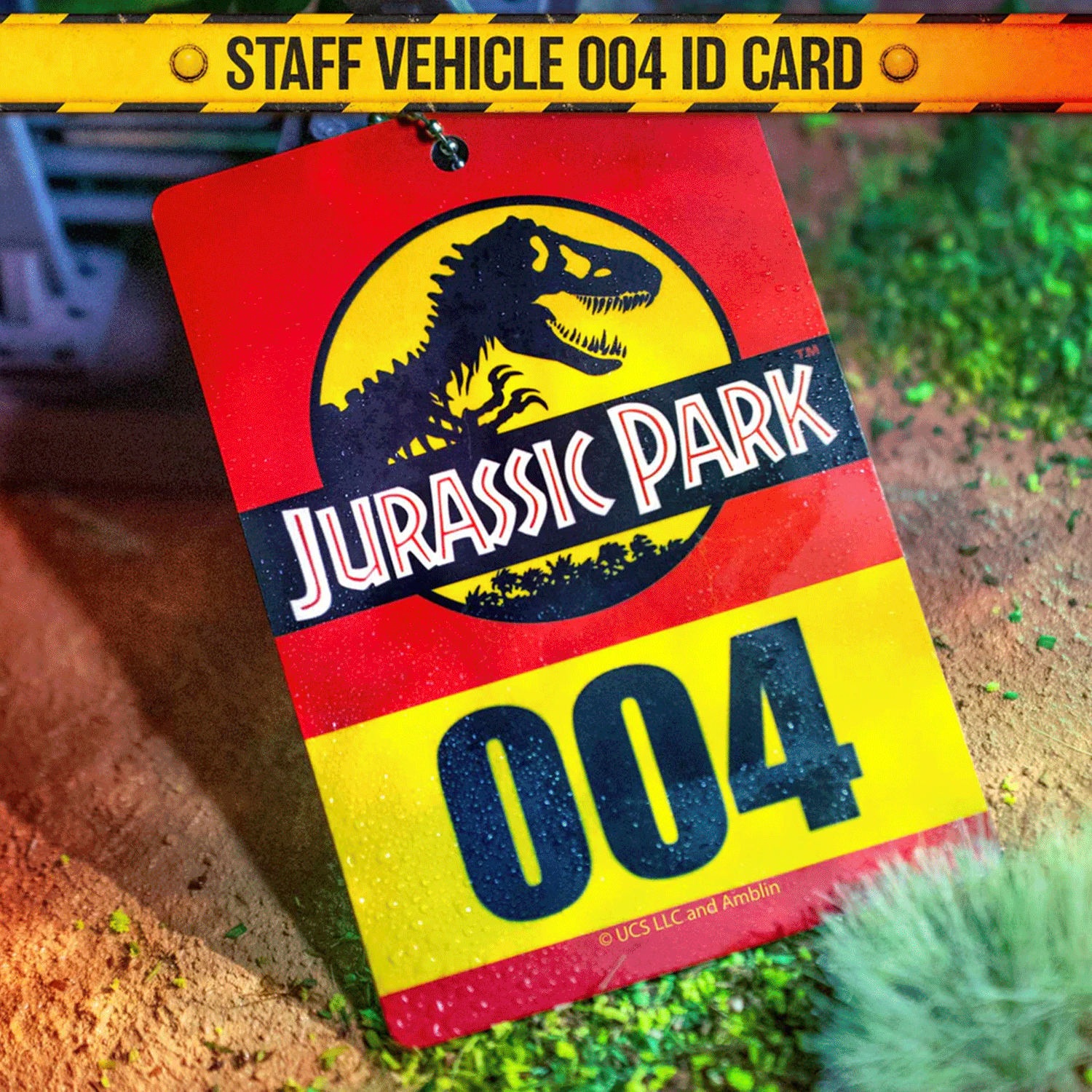 Doctor Collector Jurassic Park staff vehicle ID card marked 004 with iconic dinosaur logo on textured natural ground background