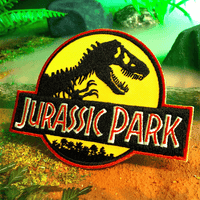 Doctor Collector Jurassic Park embroidered patch featuring classic dinosaur logo with yellow and red border on forest background