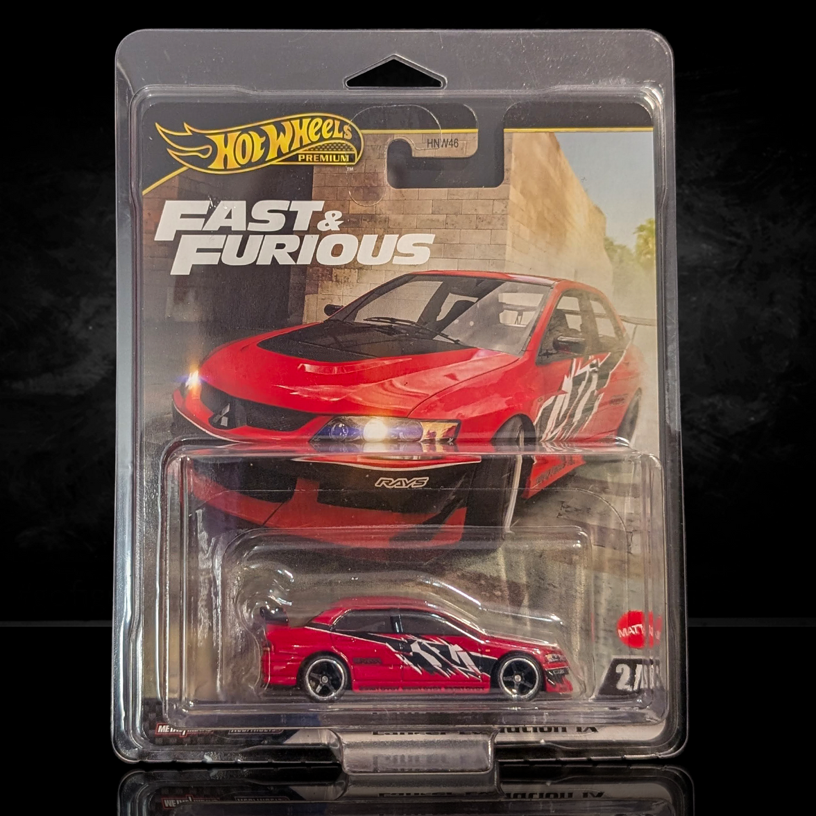Hot Wheels Fast & Furious die-cast car in red with black and white racing stripes, packaged in branded blister pack