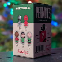 Super7 Peanuts Holiday Blind Box packaging showing collectible characters including Holiday Lucy Van Pelt and mystery figure