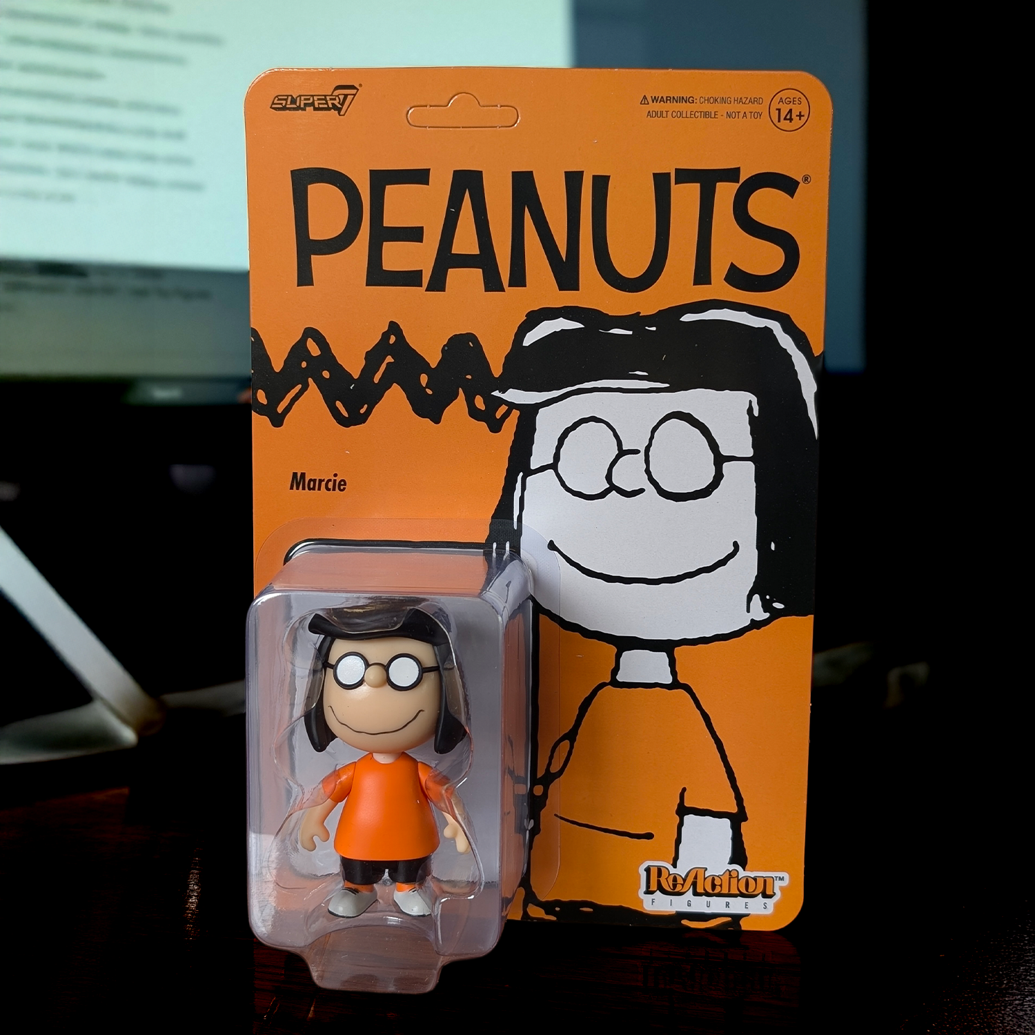 Peanuts character figure in packaging with orange background
