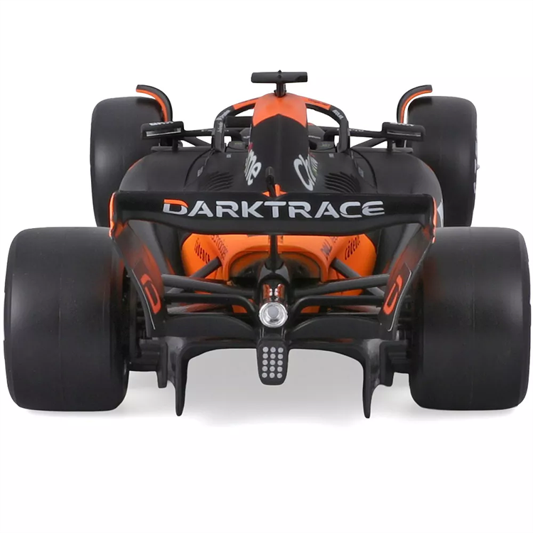 Bburago die-cast 1:43 scale McLaren MCL38 Formula 1 car in papaya orange with Oscar Piastri's helmet detail.